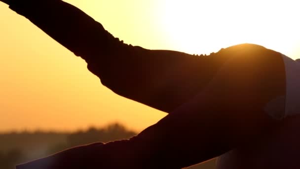 Mujer deportiva se acuesta en una pelota y levanta la pierna al atardecer — Vídeos de Stock