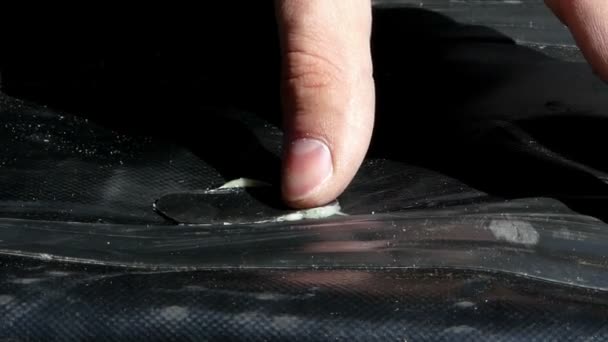 Un parche de goma se pone en un neumático con un pegamento blanco para fijar el agujero . — Vídeos de Stock