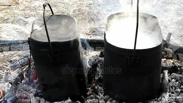 Two smoldering cauldrons with hot watet on charcoal in slow motion. — Stock Video
