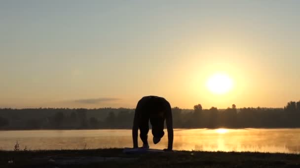 La mujer corre tocando la orilla del lago al atardecer — Vídeos de Stock