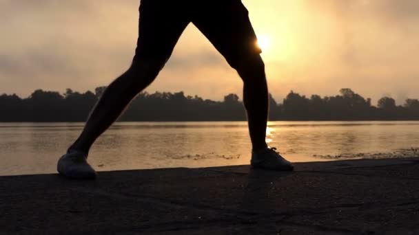 Erkek bacakları dans muhteşem bir günbatımı Slo-Mo, etkileyici bir nehir üzerinde — Stok video