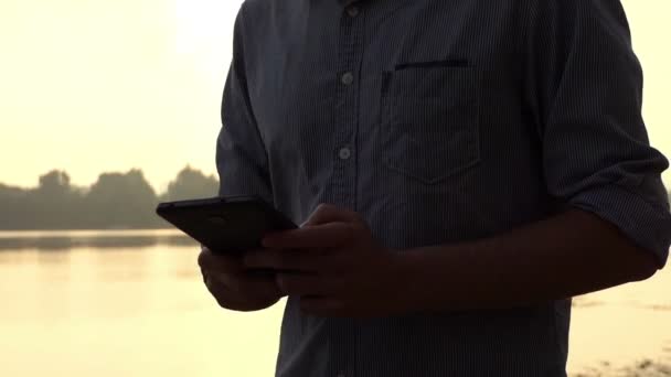 Fiatal Mans kezében munka Smartphone-on a Dnipro, nyáron a Slo-Mo — Stock videók