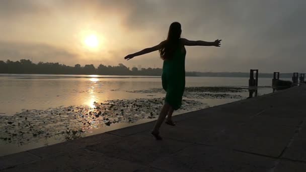 Жінка пробігає на березі покриті бетонними плитами на заході сонця в Slo-Mo — стокове відео