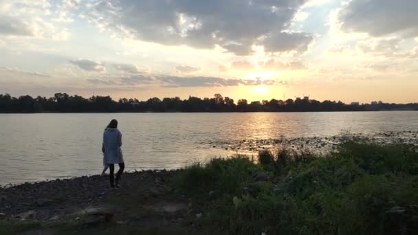 Młody mężczyzna i kobieta stoi na brzegu rzeki. Człowiek rzuca kamieniem — Wideo stockowe
