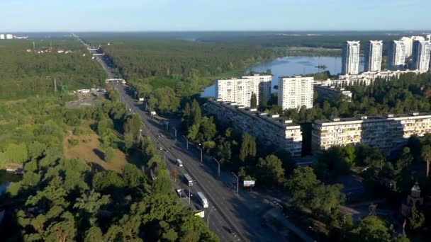 Antenn skott av en motorväg bland grönska och höga byggnader i sommar — Stockvideo