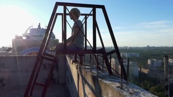 Metal merdiven ve lotus asana yüksek bir bina üzerinde bir adam — Stok video