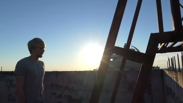 Een dakdekker man klimt de oude trap van een zeer hoog gebouw — Stockvideo