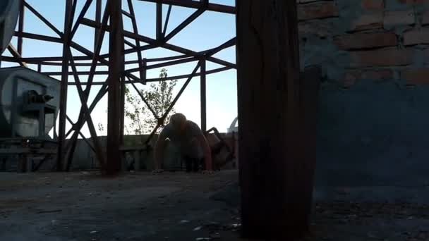 一个建筑工地上的金发男人做一个推和跳跃 — 图库视频影像