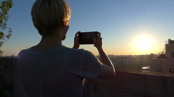 Блондинка стріляє чудовий захід сонця з високої будівлі в шлю-мо — стокове відео