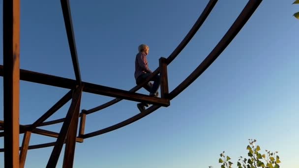 L'homme rêveur est assis sur une construction métallique au coucher du soleil à Montréal- mo — Video