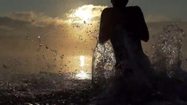 Homem esportivo corre e salta em um lago ao pôr do sol em slo-mo — Vídeo de Stock