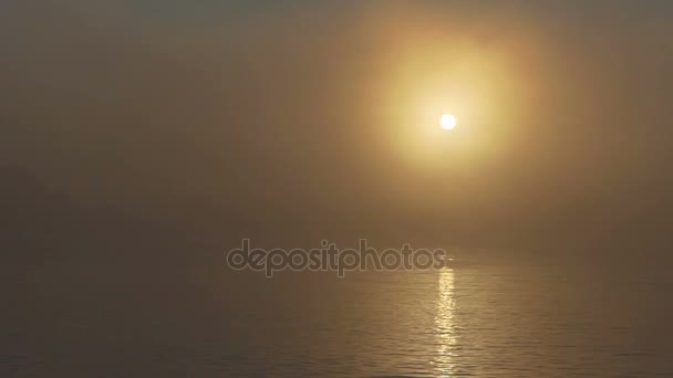 Una densa niebla cubre el lago en una espléndida puesta de sol en verano — Vídeo de stock