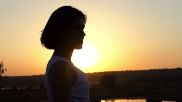 Ελκυστική νεαρή γυναίκα μοιάζει Romantically μακρινό στο υπέροχο ηλιοβασίλεμα σε Slo-Mo — Αρχείο Βίντεο
