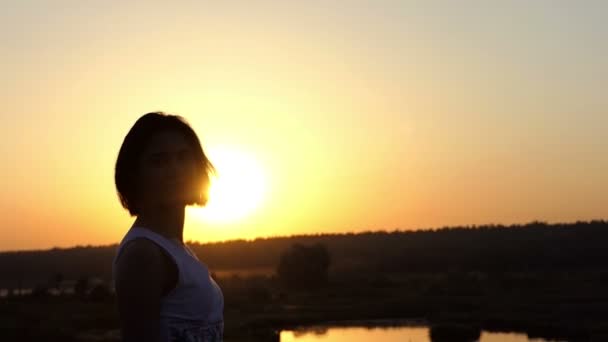 Genç kadın döner kafasını etkileyici ve vücudu Slo-mo gün batımında dantel elbise — Stok video