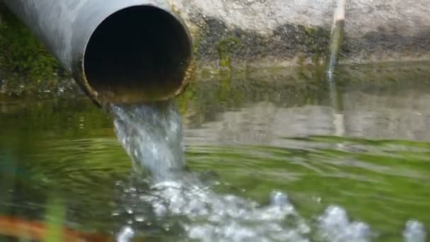 Un ampio tubo con spruzzi d'acqua che cadono in un lago in slo-mo — Video Stock