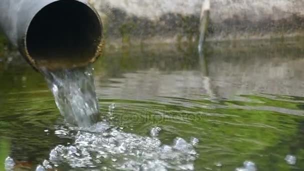 A wide tube with bubbling water falling into a lake in slo-mo — Stock Video