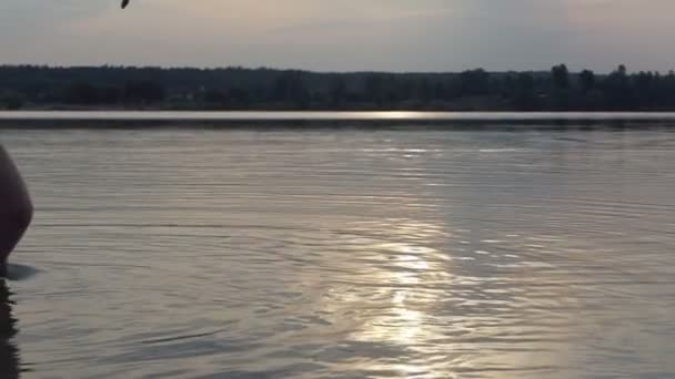 Jonge man gooit een kiezelsteen springen op lake wateren in slo-mo — Stockvideo