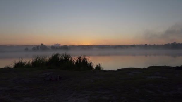 Ein See bei einem herrlichen Sonnenuntergang im Sommer. Es ist mit Nebel bedeckt. — Stockvideo