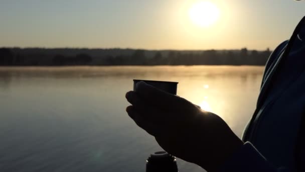 4k - ženské ruce drží šálek kávy na břehu jezera při západu slunce — Stock video