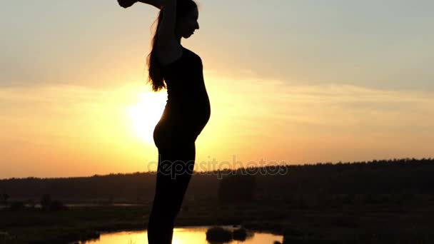 Mujer embarazada jugar con sus pelos al atardecer en cámara lenta . — Vídeo de stock