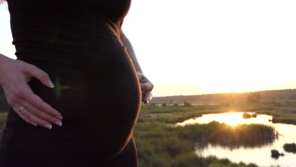 Handen van zwangere vrouw speelt met haar maag in slow motion. — Stockvideo