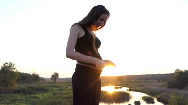 年轻怀孕的女孩玩她的胃. — 图库视频影像