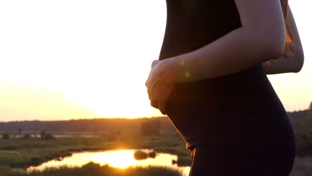 Εκπληκτικό στιγμιότυπο από μελλοντική μητέρα με μεγάλο στομάχι στο ηλιοβασίλεμα. — Αρχείο Βίντεο