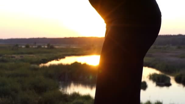 Zwanger meisje bij zonsondergang dansen en toucing haar stomatch. — Stockvideo