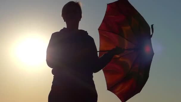 Γυναίκα περιστρέφεται μια ομπρέλα καφέ με ένα ωραίο ηλιοβασίλεμα — Αρχείο Βίντεο