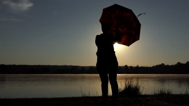 Mujer feliz gira su paraguas marrón al atardecer en slo-mo — Vídeos de Stock