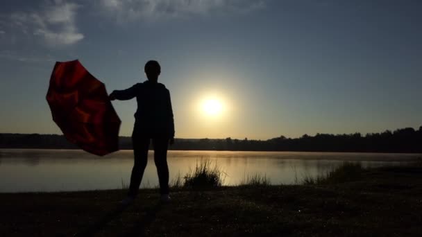 Χαρωπή γυναίκα sways καφέ ομπρέλα της στο ηλιοβασίλεμα σε slo-mo — Αρχείο Βίντεο