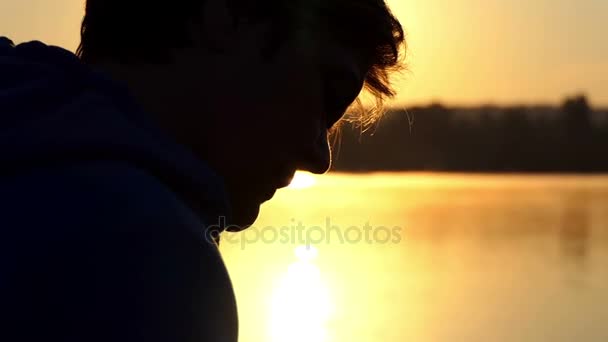 Happy woman looks at photos at a lake at sunset — Stock Video