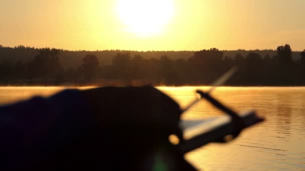 Nobla kvinnan ser på foton på en sjö vid solnedgången i slo-mo — Stockvideo