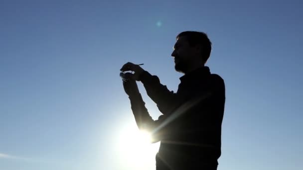 4 k gün batımında güneş gözlüklerini üzerinde genç erkek koyar — Stok video