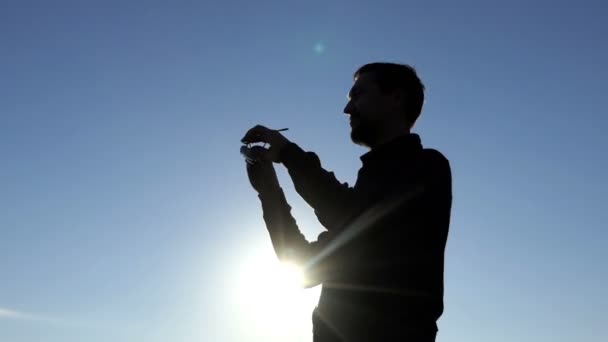 Joven se pone sus gafas de sol al atardecer en 4k — Vídeos de Stock