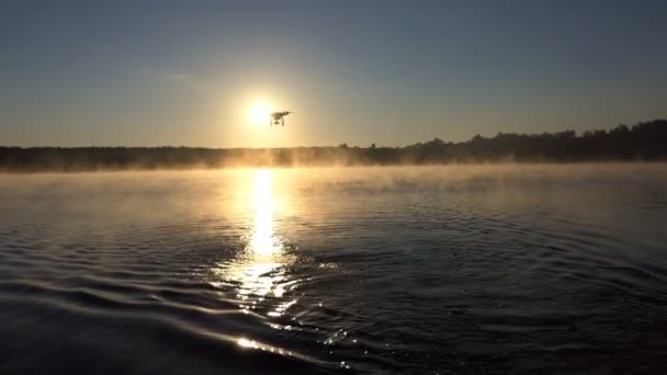 Een prachtig meer bij zonsondergang en een drone vliegt over het in slo-mo — Stockvideo