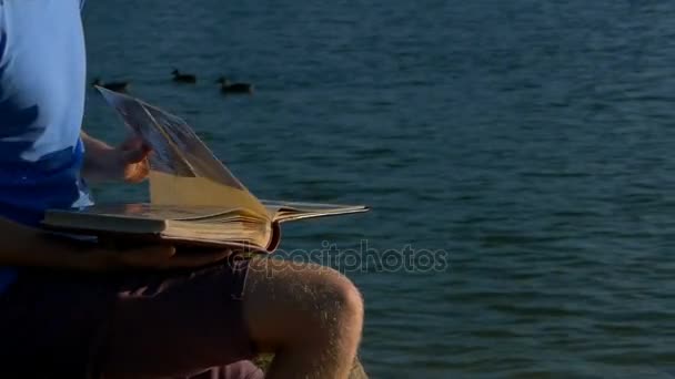 Adam fotoğraf göl kıyısında bakar. Yakın ördek yüzmek — Stok video