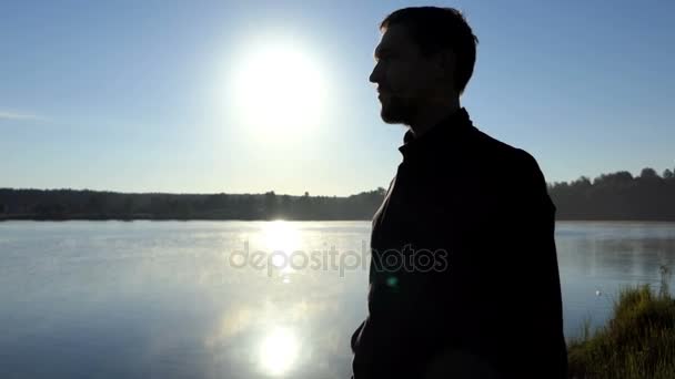 Brodaty mężczyzna kładzie się na stylowe okulary o zachodzie słońca w 4k — Wideo stockowe