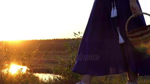 Lekfulla kvinnan går och roterar en folklig korg vid solnedgången i slo-mo — Stockvideo