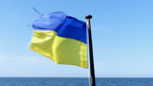 A Ukrainian flag flutters on a flagpole over the sea — Stock Video