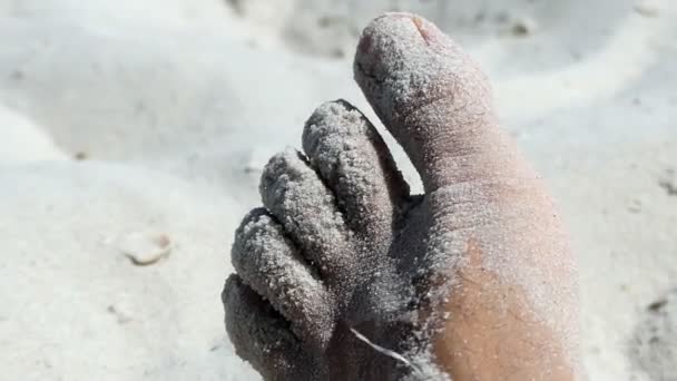 Gros plan d'un pied mâle sur une plage de sable fin en été . — Video