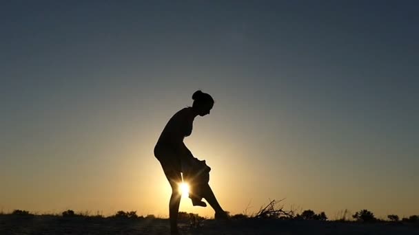 Ung kvinna torkar sin kropp med en handduk i solnedgången — Stockvideo