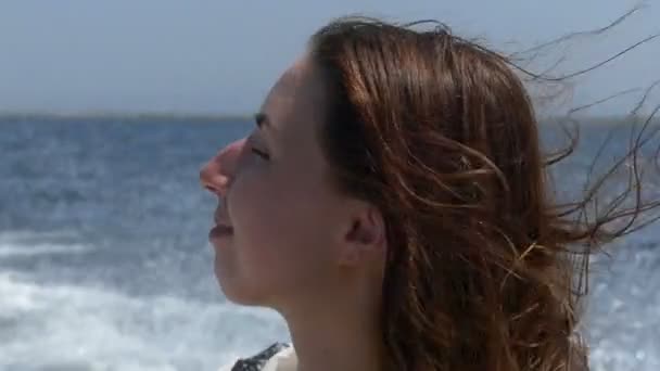 Молодая женщина улыбается в движущейся моторной лодке в сло-мо — стоковое видео