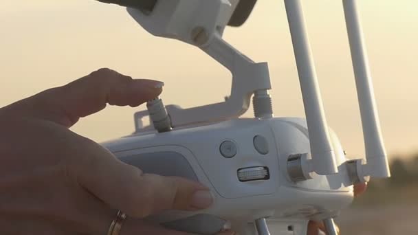 Le mani femminili azionano il pannello di controllo di un drone su una costa sabbiosa — Video Stock