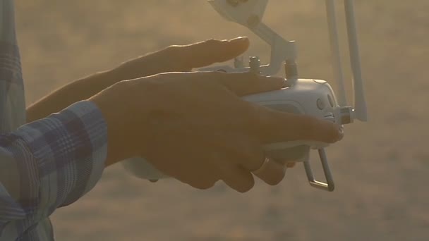 Mani femminili con il pannello di controllo di un quadricopter una costa — Video Stock
