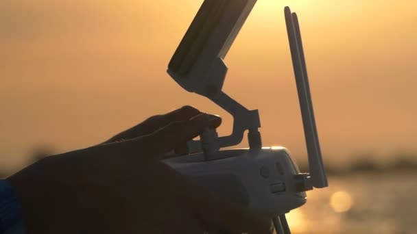 Frauenhände steuern die Drohnensteuerung bei Sonnenuntergang — Stockvideo