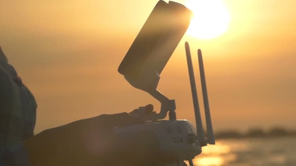 Dames handen druk op het bedieningspaneel van de drone bij zonsondergang in slo-mo — Stockvideo