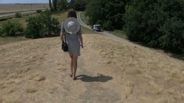 Jonge vrouw in een gestreepte jurk gaat naar een vrachtwagen in slo-mo — Stockvideo