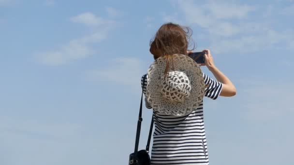 Jonge vrouw in een gestreepte jurk schiet buitenshuis in slo-mo — Stockvideo