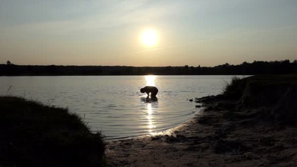 Junger Mann findet seine Meisterschale in einem See und freut sich über Slo-mo — Stockvideo